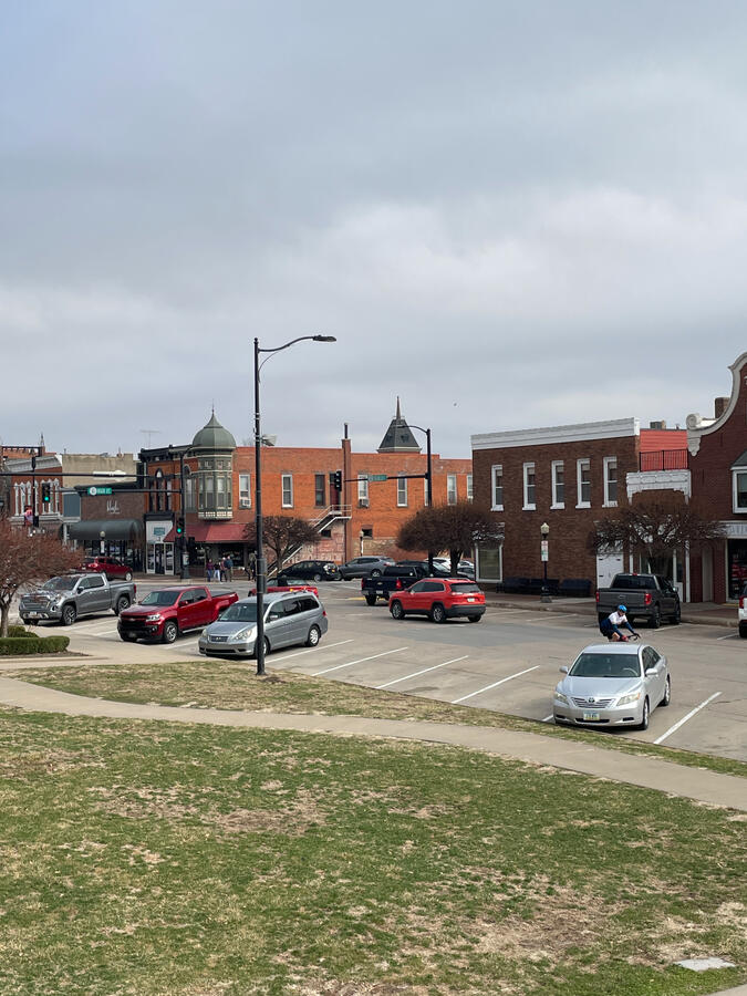 pella-downtown-street-view-central-district Downtown Pella street scene with storefronts, brick sidewalks, and parked cars.