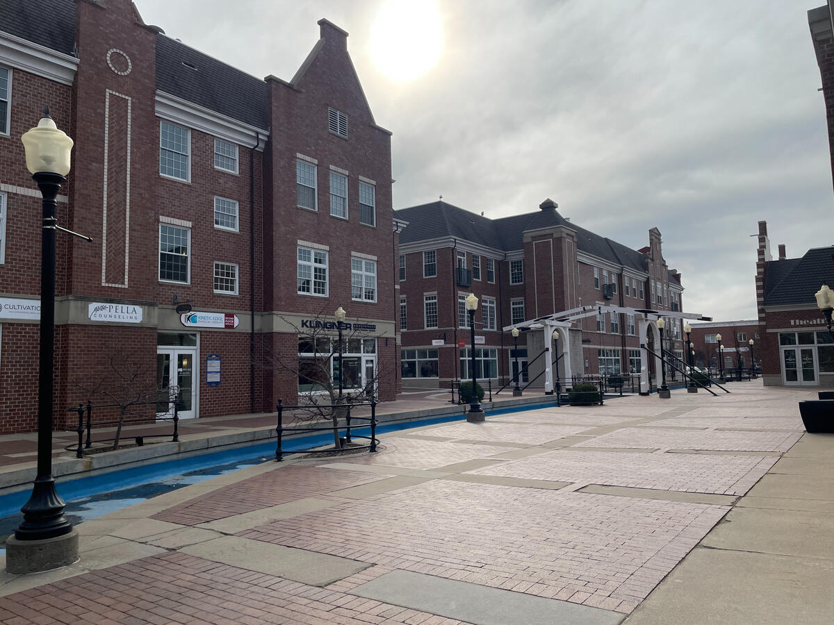 pella-molengracht-canal-plaza Molengracht canal with brick plaza, benches, and Dutch‑inspired mixed‑use buildings.