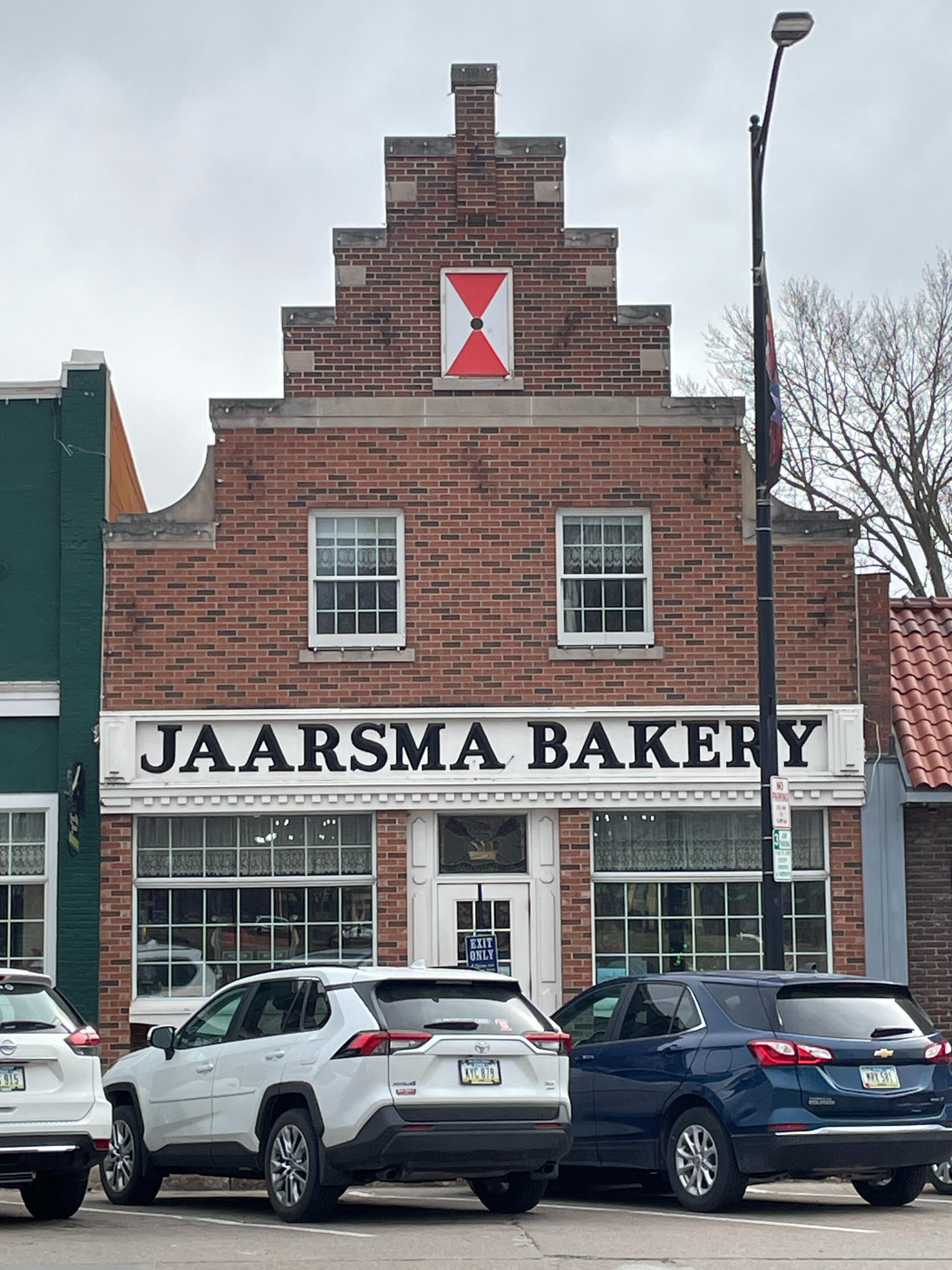 pella-jaarsma-bakery-historic-exterior Front of Jaarsma Bakery with its stepped gable façade and street parking in downtown Pella.